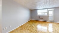 This well-laid-out two-bedroom, one-bathroom unit at 230 Nipigon Avenue in Oshawa offers a comfortable and functional living space across a single floor. A welcoming entrance leads into the open combined living and dining area, which is highlighted by warm, polished parquet flooring and a decorative textured ceiling. Natural light filters in through windows, creating a bright and airy atmosphere, while baseboard heating ensures year-round comfort. The space extends to a private balcony, providing a pleasant outdoor retreat.

The kitchen is clean and efficient, featuring white cabinetry, light tile flooring, a countertop with a built-in sink, and white appliances including a stove and refrigerator. Both bedrooms continue the parquet flooring theme and are well-sized, each featuring windows that bring in natural light and views of the surrounding area. The primary bedroom includes a double-door closet for generous storage. In total, the unit benefits from four closets throughout, offering ample storage solutions.

The full bathroom is finished with white tile surrounding a tub-shower combination, a toilet, and a vanity with a marble-style countertop, set on neutral tile flooring. A hallway connects all rooms cohesively, completing this practical and comfortable unit in Oshawa.