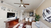 This one-bedroom, one-bathroom residence in Durham, NC offers a thoughtfully designed open-concept layout that maximizes its cozy footprint. The combined living and dining area flows seamlessly into the kitchen, creating an inviting, connected space. Crown molding, warm neutral tones, and wood-style flooring lend a polished feel throughout, while ceiling fans in every room add both comfort and style. Large windows flood the living area with natural light, enhancing the airy atmosphere.

The kitchen is equipped with dark espresso cabinetry, light countertops, black appliances including an electric range and built-in microwave, a double-basin sink, and pendant lighting — all accented by track lighting overhead and crown molding details.

The bedroom offers a comfortable, carpeted retreat with a ceiling fan, a window with natural light, and direct access to the bathroom. The bathroom features dark vanity cabinetry with light countertops, wood-style tile flooring, and a full soaking tub set within an elegant arched alcove with tile surround. A hallway and dedicated closet provide practical storage. This residence combines functional design with refined finishes throughout.