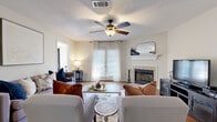 Located at 1715 Reserve D in Clinton, Mississippi, this single-story, 2-bedroom, 2-bathroom home offers a thoughtfully designed layout across a comfortable footprint. The living room serves as the heart of the home, featuring rich hardwood-style flooring, a ceiling fan with light fixture, a tiled fireplace with a classic white mantel, and French doors that invite natural light throughout. The adjacent dining room makes a bold statement with a deep teal accent wall, modern chandelier, and hardwood-style floors that flow seamlessly from the living areas. The kitchen provides ample cabinetry with light wood trim, white appliances, generous counter space, and a double sink, all complemented by hardwood-style flooring. The spacious primary bedroom features plush carpet, a ceiling fan, and abundant natural light, with access to a walk-in closet outfitted with wire shelving. The second bedroom offers its own distinctive character with carpet flooring, a ceiling fan, and bold accent wall detailing. Both bathrooms include vanities with white countertops and tub-shower combinations. A dedicated laundry room with wire shelving and utility hookups adds everyday convenience to this well-appointed Clinton home.