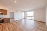Located at 3222 Mission Village Dr in San Diego, CA, this modern 1-bedroom, 1-bathroom unit offers a thoughtfully designed open-concept layout. The combined living, dining, and kitchen area is bright and airy, featuring light wood-tone flooring, crisp white walls, and large sliding windows and a glass door that open to a private balcony, flooding the space with natural light and outdoor views of the surrounding neighborhood.

The kitchen is well-appointed with contemporary flat-front cabinetry in a warm wood finish, white quartz countertops, a clean tile backsplash, and a full suite of stainless steel appliances including a refrigerator, dishwasher, electric range, and built-in microwave. A wall-mounted mini-split system provides efficient climate control throughout the living area.

The bedroom is comfortably sized, finished with plush carpeting, and features large windows that bring in ample natural light and outdoor views. A dedicated closet offers convenient storage.

The bathroom is clean and modern, featuring a wood-finish vanity with a white countertop, an undermount sink, and a well-placed mirror with overhead lighting. Additional amenities include a dedicated laundry area and a utility room, rounding out this well-equipped San Diego residence.
