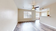 This single-floor residence offers a thoughtfully laid-out interior with a clean, neutral aesthetic throughout. The open living area is a standout feature, showcasing rich wood-look laminate flooring, warm beige walls, and a textured ceiling with a ceiling fan and light fixture. Multiple windows dressed with horizontal blinds allow abundant natural light to fill the space, creating a bright and welcoming atmosphere.

The kitchen is designed for functionality, featuring a galley-style layout with white cabinetry, a mosaic tile backsplash, white appliances including an electric range and refrigerator, and a walk-in pantry for added storage. A peninsula counter with a double sink opens toward the living area, enhancing the connected feel of the common spaces.

The bedrooms offer a comfortable retreat, finished with plush carpeting, neutral walls, and windows that bring in natural light. Each room provides a calm and versatile environment suitable for a variety of uses.

The bathroom includes a full-size soaking tub and shower combination with clean white surroundings. A dedicated entry area with durable laminate flooring and a paneled front door provides a practical and welcoming transition into the home. Overall, this residence delivers a cohesive, move-in-ready interior with consistent finishes and practical design throughout.