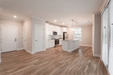 Located at 9610 23rd Bay St in Norfolk, Virginia, this well-appointed single-floor residence offers a thoughtfully designed open-concept layout that seamlessly connects the living, dining, and kitchen areas. Rich hardwood flooring flows throughout the main living spaces, complemented by crown molding and ceiling fans that add a refined touch to the interior.

The gourmet kitchen serves as the heart of the home, showcasing crisp white shaker cabinetry, granite countertops, a large center island with an undermount sink, stainless steel appliances, a tile backsplash, and stylish pendant lighting. A dining nook with multiple windows invites natural light and neighborhood views.

The living area opens to an outdoor space through full-length glass French doors, further enhancing the bright and airy ambiance. Bedrooms are carpeted for comfort, with generous closet storage and large windows providing ample natural light. The bathrooms are elegantly finished with marble-style tile flooring and surround, granite vanity countertops, and modern fixtures. A dedicated laundry room with a full-size washer and dryer adds everyday convenience. The overall aesthetic is clean, contemporary, and move-in ready.