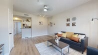 Located at 1822 N Perkins Rd in Stillwater, Oklahoma, this single-floor unit offers a well-designed layout that balances functionality and comfort. The open-concept living area is bright and inviting, featuring light wood-style flooring, a ceiling fan with track lighting, and a large window dressed with warm golden curtains that allow natural light to fill the space. The kitchen is efficiently arranged with crisp white cabinetry, dark granite countertops, stainless steel appliances including a refrigerator and dishwasher, and direct access to an in-unit laundry closet — a highly practical feature. The unit includes two bedrooms, each carpeted for added warmth. One bedroom features mirrored sliding closet doors and a dedicated desk area, while the other offers a window with outdoor views and ample space for a full-size bed and study setup. Two full bathrooms serve the unit, each featuring a tub-shower combination with clean white tile surrounds, wood-style flooring, and overhead cabinetry for storage. Neutral wall tones throughout the unit create a calm, cohesive aesthetic that is easy to personalize. The thoughtful floor plan and included amenities make this a practical and comfortable option in the Stillwater area.