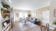 Located at 501 Highland Dr in Lewisville, TX, this single-story residence offers a well-organized layout with distinct living, dining, kitchen, bedroom, and bathroom areas, all unified by a warm neutral color palette and crown molding details.

The living room is an inviting, carpeted space featuring crown molding, sheer-curtained windows that allow generous natural light, and a comfortable seating arrangement anchored by a patterned area rug. The entryway flows directly from this room, highlighted by hardwood-style flooring near the front door.

The galley-style kitchen is efficiently designed with warm wood cabinetry, dark granite-look countertops, a double stainless steel sink, and white appliances including a range, microwave, dishwasher, and refrigerator. Hardwood-style flooring and ample cabinet storage add both practicality and character.

The dining area is an intimate space framed by tall walls, crown molding, and elevated ceilings, providing a refined setting for meals. A decorative mirror and bold artwork enhance the room's character.

The bedroom is a tranquil retreat with plush carpeting, a ceiling fan, and a bright window overlooking a green outdoor view, offering a peaceful and private atmosphere.

The bathroom features a tiled tub-shower combination, hardwood-style flooring, and clean, functional finishes, completing this well-appointed residence.