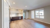 This 610-square-foot, one-bedroom, one-bathroom apartment at North Grove in Riverside, California, offers a thoughtfully designed single-floor layout ideal for comfortable urban living. The contemporary kitchen is a standout feature, equipped with stainless steel appliances including a full-size refrigerator, range, microwave, and dishwasher. Two-tone cabinetry — white uppers paired with wood-grain lowers — is complemented by a classic subway tile backsplash and recessed lighting, creating a clean, modern aesthetic. Light hardwood-style flooring flows throughout the main living areas, enhancing the bright, airy feel of the space. The 120-square-foot bedroom is finished with plush carpet, large windows that invite natural light and outdoor views, and a dedicated closet for ample storage. A hallway connects the rooms seamlessly, providing a functional flow through the unit. The bathroom features a combined shower and tub, a wood-grain vanity with an integrated sink and large mirror, and matching hardwood-style flooring that ties the space together. Neutral wall tones throughout the apartment create a versatile backdrop. A HVAC system with ceiling vents ensures year-round comfort in this well-appointed Riverside residence.