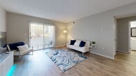Located at 6115 N Davis Hwy in Pensacola, Florida, this 2-bedroom, 1-bathroom single-story home offers a practical and comfortable layout with clean, neutral finishes throughout. The living room is bright and welcoming, featuring wood-look flooring, a textured ceiling, and a sliding glass door that opens to a private outdoor patio, allowing natural light to fill the space. A dedicated area adjacent to the living room provides flexible space for a dining or media setup, complete with matching flooring and a modern low-profile media console. The kitchen is well-equipped with white shaker-style cabinetry, dark granite-look countertops, stainless steel appliances including a range and dishwasher, a double-basin sink, and a window that brings in additional natural light. The primary bedroom is generously sized, featuring plush carpet, a ceiling fan, a bright window with curtains, and a spacious walk-in closet with built-in shelving. The second bedroom also offers carpet flooring and a ceiling fan, providing a cozy and functional retreat. The bathroom features a white vanity with ample cabinet storage, a framed mirror, and clean, simple finishes. Three closets throughout the home ensure excellent storage capacity.