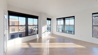 Located in the heart of Washington, DC's dynamic U Street neighborhood, this thoughtfully designed unit at 1315 W St NW offers a clean, modern aesthetic across a well-appointed single-floor layout. The open living area is bathed in natural light through expansive floor-to-ceiling windows with bold dark frames, showcasing sweeping panoramic views of the surrounding cityscape. Light-toned hardwood flooring runs throughout the main living spaces, enhancing the bright, airy atmosphere. The kitchen is outfitted with rich dark cabinetry, stainless steel appliances including a range, microwave, and dishwasher, and a decorative tile backsplash that adds a contemporary touch. The bedrooms feature soft wall-to-wall carpeting, generous closet space, and large windows that frame views of the urban surroundings. The bathrooms are finished with clean white tile surrounds in the tub-shower combinations, chrome fixtures, and light tile flooring. One bathroom also includes a dark-toned vanity with a wide mirror and modern lighting. Throughout the unit, crisp white walls and consistent design elements create a cohesive, modern living environment well-suited to urban life in one of DC's most sought-after neighborhoods.
