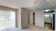 Located at 2310 W Cameo Ln in Knightdale, NC, this single-floor home offers a functional and comfortable layout throughout. The interior is finished with neutral-toned walls and plush carpeting across the main living and bedroom areas, creating a warm and cohesive aesthetic.

The living room is a well-proportioned space featuring a ceiling fan with light fixture, vertical blind-covered sliding door access to a patio, and wood-look flooring at the entryway threshold. Natural light filters in through the covered patio door, brightening the room.

The kitchen is outfitted with white cabinetry providing ample storage, granite-style countertops, a double stainless steel sink, and under-cabinet lighting. The clean white finishes give the kitchen a bright, practical feel.

The bedrooms are carpeted and bathed in natural light from windows with blinds. One bedroom features a walk-in closet with built-in hanging rods, while another includes a standard closet. Each room is equipped with a ceiling fan and textured ceilings throughout.

The bathroom includes tile flooring, a vanity, toilet, and a tub/shower combination, finished in a neutral palette that complements the rest of the home. Overall, the space presents a clean, move-in-ready environment suited for comfortable everyday living.