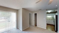 Located at 2310 W Cameo Ln in Knightdale, NC, this single-floor home offers a functional and comfortable layout throughout. The interior is finished with neutral-toned walls and plush carpeting across the main living and bedroom areas, creating a warm and cohesive aesthetic.

The living room is a well-proportioned space featuring a ceiling fan with light fixture, vertical blind-covered sliding door access to a patio, and wood-look flooring at the entryway threshold. Natural light filters in through the covered patio door, brightening the room.

The kitchen is outfitted with white cabinetry providing ample storage, granite-style countertops, a double stainless steel sink, and under-cabinet lighting. The clean white finishes give the kitchen a bright, practical feel.

The bedrooms are carpeted and bathed in natural light from windows with blinds. One bedroom features a walk-in closet with built-in hanging rods, while another includes a standard closet. Each room is equipped with a ceiling fan and textured ceilings throughout.

The bathroom includes tile flooring, a vanity, toilet, and a tub/shower combination, finished in a neutral palette that complements the rest of the home. Overall, the space presents a clean, move-in-ready environment suited for comfortable everyday living.