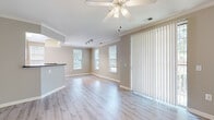 Located in the King Farm community of Rockville, MD, this well-appointed 3-bedroom, 2-bathroom single-floor home offers a comfortable and functional layout. The open living room is bright and welcoming, featuring light hardwood-style flooring, crown molding, a ceiling fan, and multiple windows that invite an abundance of natural light. A sliding glass door with vertical blinds opens to the outdoors, further enhancing the airy feel of the space. The kitchen is efficiently designed with light wood cabinetry, dark granite-style countertops, black appliances including a refrigerator and microwave, and a peninsula that provides additional prep space and casual seating. The three bedrooms are carpeted and comfortably sized, each offering good natural light through large windows. The spacious primary bedroom includes a walk-in closet outfitted with wire shelving and hanging rods for generous storage. Secondary bedrooms feature double-door closets. Both bathrooms are finished with tile flooring, warm wood vanity cabinets, and a tub-shower combination. Two hallways connect the rooms efficiently throughout the home, and a dedicated closet provides additional storage.