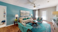 Located at 704 Shell Dr in Spring Lake, North Carolina, this single-story residence offers a thoughtfully designed layout with multiple bedrooms, a fully equipped kitchen, and comfortable living spaces throughout. The living room serves as a central gathering area, featuring wood-look flooring, a ceiling fan, and a sliding glass door that invites natural light and outdoor access. A textured ceiling adds architectural character to the space.

The kitchen is outfitted with warm wood cabinetry, dark granite-style countertops, and black and stainless steel appliances including an electric range, refrigerator, and dishwasher. A peninsula provides additional counter space, while an adjacent dining area accommodates everyday meals. A dedicated laundry area with a washer is conveniently accessible directly from the kitchen.

The bedrooms are carpeted and well-sized, each featuring ceiling fans or flush-mount lighting and windows that allow natural light. One bedroom includes a walk-in closet, while others feature double-door closets. The bathrooms are finished with wood-look flooring, rich wood vanities, and granite-style countertops — one bathroom offers a dual-sink vanity with a wide mirror and strip lighting above.