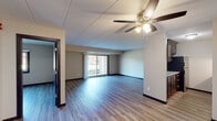 Located at 907 Vale Park Rd in Valparaiso, Indiana, this single-floor unit offers a well-designed, functional layout with a clean and modern aesthetic throughout. The open-concept living and dining area is finished with durable wood-style plank flooring and neutral-toned walls, creating a bright and welcoming atmosphere. A ceiling fan with integrated lighting adds both comfort and practicality to the space. A sliding glass door at the far end of the living area fills the room with natural light and provides views of the outdoors. The galley-style kitchen is thoughtfully appointed with rich dark wood cabinetry, light granite countertops, a classic subway tile backsplash, and stainless steel appliances including a gas range and built-in microwave. A double-basin sink and ample upper and lower cabinet storage complete the kitchen. The kitchen opens toward the main living space via a pass-through counter, enhancing the overall flow of the floor plan. The bathroom features a full tub and shower combination, a dark wood vanity with a white sink basin, brushed nickel fixtures, and wood-style flooring that ties seamlessly into the rest of the unit. Additional interior doors provide access to private spaces within the layout. Overall, the unit presents a cohesive, updated interior with practical finishes suited for comfortable everyday living.