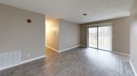 Located at 102 Brentway Cir in Knoxville, Tennessee, this single-story, 3-bedroom, 2-bathroom home offers a practical and comfortable layout designed for everyday living. The entrance opens into a welcoming hallway with wood-look tile flooring and clean white trim, connecting the main living spaces seamlessly. The living room is bright and open, featuring the same wood-look tile flooring and a large sliding glass door that floods the space with natural light and provides outdoor views. The combined dining and kitchen area is conveniently situated adjacent to a dedicated pantry for additional storage. All three bedrooms are carpeted and equipped with ceiling fans and natural light from exterior windows. The generously sized primary bedroom includes an en-suite bathroom and ample closet space. The secondary bedrooms each feature built-in closets with louvered bifold doors. With five total closets throughout the home, storage is plentiful. The two bathrooms are well-appointed — one includes a tub/shower combo with tile surround, while the other features a granite-topped vanity with an undermount sink and framed mirror. Neutral warm-gray tones carry throughout, creating a cohesive, move-in ready aesthetic.