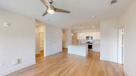 Located at 2410 Smith Gln Rd in Charlotte, NC, this well-appointed 2-bedroom, 2-bathroom single-story home offers a clean, modern aesthetic throughout. Light wood-style flooring flows seamlessly across all rooms, creating a cohesive and inviting atmosphere. The open-concept kitchen and living area serves as the heart of the home, showcasing white shaker-style cabinetry, granite countertops, a herringbone tile backsplash, stainless steel appliances, and a central island with pendant lighting — ideal for both everyday living and entertaining. Both bedrooms are comfortably sized, featuring ceiling fans, large windows with blinds that invite abundant natural light, and views of the surrounding greenery. The primary bedroom includes its own dedicated closet with built-in shelving, offering practical storage. Each of the two bathrooms is finished with granite-topped vanities, wood-look flooring, and full tub-shower combinations with built-in shelving. Two closets throughout the home provide ample storage. The consistent use of neutral tones, crisp white walls, and modern fixtures gives the space a bright, clean, and move-in-ready feel.