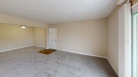 This well-designed apartment in Virginia Beach offers 980 square feet of comfortable living space on a single floor. The layout includes three bedrooms, two full bathrooms, a combined kitchen and living room, two closets, and a hallway. The primary bedroom is generously sized at 190 square feet, providing ample space for relaxation.

The kitchen is a standout feature, boasting modern appliances, dark wood cabinetry, and granite countertops. The living area is spacious and bright, with an arched window that allows natural light to flood the room. Plush carpeting in the bedrooms and living spaces adds warmth and comfort, while the kitchen and bathrooms feature durable wood-look flooring.

One of the bedrooms offers sliding glass door access to a balcony, perfect for enjoying outdoor views. The bathrooms are equipped with modern fixtures, including a combination bathtub and shower. Throughout the apartment, neutral paint tones create a clean and inviting atmosphere, allowing for personalized decor. The overall design promotes an open and airy feel, making this apartment an ideal living space for comfort and functionality.