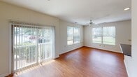 Located at 13215 Steelecroft Pkwy in Charlotte, NC, this single-floor residence offers a well-designed layout with a clean, neutral aesthetic throughout. The open living area is bright and welcoming, featuring warm hardwood-style flooring, a ceiling fan, and large windows fitted with blinds that fill the space with natural light and offer views of the surrounding greenery. A sliding glass door further enhances the connection to the outdoors.

The kitchen is efficiently laid out and features light wood cabinetry, dark granite-style countertops, and black appliances including a refrigerator, range, and over-the-range microwave. A peninsula counter provides a natural transition between the kitchen and living area.

The bedrooms are carpeted for comfort, each with windows that bring in ample natural light. The primary bedroom includes access to a private en-suite bathroom equipped with a walk-in glass shower, a single-sink vanity with dark countertops, white cabinetry, and hardwood-style flooring. A second full bathroom features a tub-shower combination, a matching vanity setup, and consistent finishes. The interior maintains a cohesive, neutral color palette with white trim and warm tones throughout, creating a calm and functional living environment.