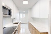 Located at 10025 115 St NW in Edmonton's vibrant Oliver neighbourhood, this well-appointed 2-bedroom, 2-bathroom unit offers a clean, modern aesthetic throughout. Light-toned hardwood flooring flows seamlessly across the open-concept living and dining area, which is bathed in natural light through large windows overlooking the city skyline. The spacious living area connects to a generously sized balcony, accessible through sliding doors, offering sweeping panoramic views of the surrounding Edmonton cityscape and green spaces below.

The kitchen features white cabinetry paired with warm wood-toned lower cabinets and modern appliances, creating a functional and visually appealing workspace. Both bedrooms are well-proportioned, each equipped with mirrored sliding closet doors that enhance the sense of space and reflect natural light. The bedrooms also feature windows with city views and baseboard heating.

The two bathrooms are finished with marble-effect porcelain tile on both the floors and shower/tub surrounds, complemented by warm wood vanity cabinets, white countertops, and bright vanity lighting. The overall palette throughout the unit is crisp white with natural wood accents, creating a clean, contemporary, and welcoming atmosphere.