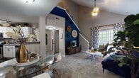 Located at 3745 Gabrielle Ln in Aurora, IL, this two-story residence offers a thoughtfully designed layout with standout architectural details and modern finishes throughout. The main living area immediately impresses with soaring vaulted ceilings and a bold navy blue accent wall that stretches dramatically upward alongside the staircase, creating a striking focal point. Plush carpeting, a large sliding glass door, and access to a private balcony bring in abundant natural light and outdoor views. A dedicated dining area sits adjacent, making the open lower level ideal for both relaxing and entertaining. The kitchen is well-appointed with crisp white shaker cabinetry, grey quartz-style countertops, a subway tile backsplash, stainless steel appliances including a gas range and dishwasher, and rich dark hardwood-style flooring. Upstairs, the bedrooms are generously sized with plush carpet, neutral tones, and accent walls in calming blue hues. One bedroom features a window seat, offering a cozy nook with natural light. The bathrooms are finished with tiled tub-shower combinations, dark hardwood-style flooring, and clean white vanities, providing a polished and functional space.