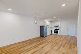 Located at 8701 Old Spanish Trail in Ocean Springs, Mississippi, this well-designed 2-bedroom, 2-bathroom residence offers a bright, modern interior with a cohesive aesthetic across all rooms. Light wood-look flooring flows throughout the entire space, complementing the crisp white walls and creating a clean, airy atmosphere.

The open-concept living, dining, and kitchen area forms the heart of the home. The kitchen is outfitted with white shaker-style cabinetry, light quartz countertops, a stainless steel refrigerator, range, microwave, and dishwasher. Recessed lighting and a stylish pendant lantern fixture illuminate the space effectively.

Both bedrooms are well-proportioned, featuring ceiling fans with light fixtures and clean white walls. The primary bedroom is notably spacious, with a door leading to an adjoining room and access to a patio. The second bedroom benefits from a window with an outdoor view, bringing in natural light. Three closets provide ample storage throughout the unit.

The two bathrooms maintain the same clean, modern design, with white fixtures, wood-look flooring, and tub-shower combinations with brushed nickel hardware. A patio extends the living space outdoors. Overall, the residence presents a fresh, move-in-ready feel with consistent finishes throughout.