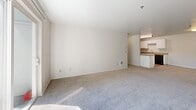 Located at 4820 NE Hazel Dell Ave in Vancouver, Washington, this single-floor, three-bedroom, two-bathroom residence offers a well-organized layout designed for comfortable everyday living. The open-concept kitchen and living room area serves as the heart of the home, featuring a bright, spacious living room with plush carpet flooring and a sliding glass door that fills the space with natural light and provides outdoor access. The kitchen is thoughtfully equipped with white cabinetry, dark countertops, wood-look flooring, and black appliances including a refrigerator, electric range, and dishwasher, creating a clean and functional cooking space. Three carpeted bedrooms provide comfortable retreats, each featuring neutral tones, natural light from windows, and baseboard heating. The generously sized primary bedroom offers ample space for furnishings. Both bathrooms are similarly appointed, each featuring a tiled shower-tub combo, wood-look flooring, and accessibility grab bars for added convenience. A dedicated closet provides additional storage. The home's neutral color palette, consistent finishes, and practical floor plan make it a versatile and move-in ready residence.