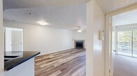 This 760 square foot apartment offers a practical and contemporary living solution. The space consists of two bedrooms, two full bathrooms, a kitchen, living room, and laundry area, all efficiently arranged on a single floor. The primary bedroom, measuring 150 square feet, provides ample space for comfort.

The living area is a highlight, featuring beautiful hardwood flooring and a stone-accented fireplace that adds warmth and character. Large sliding glass doors lead to a balcony, allowing natural light to flood the space and offering outdoor views. The kitchen, while compact, is well-equipped with wooden cabinetry, dark granite countertops, and essential appliances.

Both bedrooms are fitted with plush carpeting and ceiling fans for comfort. The bathrooms showcase modern fixtures, including a combination tub-shower unit with curved shower rods and vanities with ample storage space. The apartment includes an in-unit laundry area with a washer, dryer, and water heater for added convenience.

Throughout the apartment, neutral wall colors and textured ceilings create a blank canvas for personalization. The overall design prioritizes functionality and modern aesthetics, making it an ideal space for contemporary urban living.