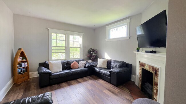 Sala de estar luminosa y acogedora con cómodos asientos, chimenea eléctrica y Smart TV de 55 pulgadas. - 822 E 4th St