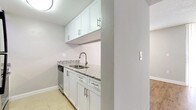 This single-floor residence offers a clean, functional layout designed for comfortable everyday living. The living area features warm hardwood-style flooring and is illuminated by track lighting, seamlessly connecting to the kitchen via a convenient pass-through counter finished with granite-style countertops. The kitchen is well-equipped with stainless steel appliances, including a range, over-the-range microwave, and dishwasher, complemented by white cabinetry and light tile flooring throughout.

A central hallway connects the main living spaces to the private areas of the home, with hardwood-style flooring transitioning to plush carpet in each of the bedrooms. The bedrooms are generously sized, each featuring natural light through blinds-equipped windows and ample storage provided by double bifold closets. The primary bedroom is notably spacious, offering a comfortable retreat.

The bathrooms are finished with granite-topped vanities, undermount sinks, and chrome fixtures. Each bathroom includes a full tub-and-shower combination with clean white tile surrounds and tile flooring. Textured ceilings are consistent throughout the space, and neutral gray walls create a cohesive, move-in-ready aesthetic across all rooms.