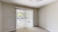 This single-floor, 2-bedroom, 1-bathroom residence offers a practical and comfortable layout designed for everyday living. The kitchen is a standout feature, showcasing white shaker-style cabinetry with matte black hardware, granite-look countertops, a subway tile backsplash, a stainless steel sink, and wood-look luxury vinyl plank flooring — giving it a clean, updated aesthetic. The living room is bright and welcoming, with plush carpeting underfoot and a sliding glass door fitted with vertical blinds that opens to an outdoor view, allowing natural light to fill the space. The spacious primary bedroom includes its own sliding glass door with vertical blinds, providing additional natural light and outdoor access, while the second bedroom features a ceiling fan with lighting and a window with blinds, offering a comfortable and well-lit retreat. Both bedrooms are finished with soft carpeting and neutral-toned walls. A dedicated closet provides additional storage. The full bathroom includes a tiled shower-tub combo, a vanity with a speckled countertop, and wood-look flooring, maintaining a cohesive and tidy finish throughout. Neutral paint tones across all rooms contribute to a calm and functional ambiance.