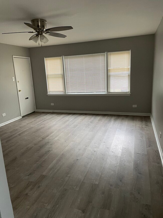 Grandes ventanales aportan luz natural a la sala de estar. - 6435 S Evans Ave