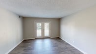 Located at 100 Stoke on Trent St in Louisville, Kentucky, this single-floor residence offers a thoughtfully designed layout with a blend of modern updates and comfortable living spaces. The main living area features durable wood-style flooring, neutral-toned walls, and a textured ceiling, creating a clean and inviting atmosphere. A standout feature is the set of French doors that open to a private balcony, flooding the space with natural light and providing pleasant outdoor views of lush greenery. The kitchen is well-equipped with white shaker-style cabinetry, granite countertops, a classic subway tile backsplash, and a full suite of stainless steel appliances, including a refrigerator, dishwasher, microwave, and range. The bedrooms are carpeted for comfort and each includes a ceiling fan with light fixture and a window offering natural light and outdoor views. The bathroom features a soaking tub and shower combination with large-format marble-look tile surround and brushed nickel fixtures, lending a polished, contemporary feel. A separate water closet with wood-style flooring and granite countertop accents provides added convenience. The entry area flows openly into the main living space, enhancing the sense of openness throughout this well-maintained home.