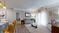 Located at 747 Worthington Woods Blvd in Columbus, Ohio, this single-story, 3-bedroom, 2-bathroom home offers a well-designed layout with comfortable living spaces throughout. The entrance opens into a corridor adorned with decorative wall art, leading to the main living areas via rich, dark hardwood-style flooring that runs throughout the common spaces.

The living room is bright and welcoming, featuring large sliding glass doors dressed with sheer white curtains that allow abundant natural light to fill the room. The kitchen is a standout feature, showcasing dark espresso cabinetry, stone-look countertops, a central island with pendant lighting, and black appliances — all seamlessly connected to a dedicated dining area.

The generously sized primary bedroom includes plush carpeting, a large window, and access to a walk-in closet with built-in wire shelving. Two additional bedrooms offer flexible use for guests or a home office. The bathrooms are clean and functional, with one featuring a full tub-shower combo with tile flooring.

A dedicated laundry room houses a full-size washer and dryer alongside additional storage shelving and a utility panel. The neutral gray color palette, consistent flooring, and thoughtful layout combine to create a cohesive, move-in-ready home.