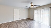 This renovated two-bedroom, two-bathroom apartment at 200 Berryhill Rd in Columbia, SC offers a well-designed single-floor layout with contemporary updates throughout. The open living room is a welcoming space, featuring durable hardwood-style flooring, a ceiling fan with light fixture, and a sliding glass door that fills the room with natural light and provides access to an outdoor area. The renovated kitchen is a standout feature, showcasing white shaker-style cabinetry, granite countertops, stainless steel appliances including a range and dishwasher, and hardwood-style flooring that ties seamlessly into the main living area. Both bedrooms are carpeted for comfort and are equipped with ceiling fans. The generously sized primary bedroom benefits from natural light through a window with blinds. A walk-in closet with wire shelving provides ample storage. Both bathrooms are cleanly finished with white cabinetry, granite-topped vanities, hardwood-style flooring, and tub-shower combinations with white surround enclosures. The neutral color palette and modern finishes throughout create a bright, cohesive, and move-in-ready living environment.