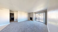 Located at 5150 E Sahara Ave in Las Vegas, this 2-bedroom, 2-bathroom residence offers a well-organized single-level layout. The spacious living room is a standout feature, showcasing plush carpeting, a tiled fireplace with a white mantel, and sliding glass doors that open to a private balcony, allowing natural light to fill the space. Adjacent to the living area, the kitchen and dining room share an open layout, with the kitchen featuring dark wood cabinetry, white countertops, tile flooring, a breakfast bar, and a window above the sink that brings in additional light. Both bedrooms are carpeted and bright, each featuring distinctive arched windows that lend a classic architectural touch. The primary bedroom is generously sized, complemented by ample closet space. The unit includes two full bathrooms: the primary bath offers a soaking tub, a dark wood vanity with a white countertop, tile-accented walls, and stylish light fixtures; the second bathroom combines a walk-in shower with in-unit washer and dryer hookups for added convenience. A utility room and multiple closets throughout provide excellent storage. The layout flows naturally from the entrance through a hallway connecting all living areas.