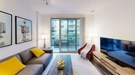 Located in the heart of Los Angeles at 1400 S Figueroa St, this modern single-floor residence offers a well-appointed, contemporary living experience. The open living area is bright and inviting, featuring sliding glass doors that lead to a private balcony with views of the surrounding urban landscape, seamlessly blending indoor and outdoor living. The space is accented with track lighting and stylish décor, including bold artwork that reflects the local LA character.

The kitchen is thoughtfully designed with dark wood cabinetry, frosted glass upper cabinets, a mosaic tile backsplash, white quartz countertops, and a full suite of stainless steel appliances including a gas range, microwave, refrigerator, and dishwasher. Wood-plank flooring runs throughout, adding warmth and continuity to the space.

The bedroom is a calm and comfortable retreat, featuring vertical blinds with ambient blue LED accent lighting, track ceiling lights, and ample room for relaxation. An adjoining bathroom is finished in clean white tile and includes a backlit vanity mirror, modern fixtures, and direct access to a walk-in closet with built-in shelving. Together, these elements create a cohesive, modern living environment in a prime Downtown Los Angeles location.