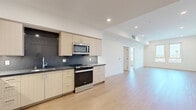Located at 1233 N Highland Ave in the vibrant Hollywood neighborhood of Los Angeles, this modern one-bedroom, one-bathroom unit offers a sleek and functional layout with contemporary design throughout. Light oak hardwood flooring flows seamlessly across the entire space, complemented by crisp white walls and recessed lighting that create a bright, airy ambiance.

The open-concept kitchen is outfitted with stainless steel appliances — including a French door refrigerator, gas range, microwave, and dishwasher — paired with light wood cabinetry, dark stone countertops, and a dark tile backsplash. The kitchen opens directly into the spacious living area, ideal for entertaining or relaxed everyday living.

The bedroom is generously sized, featuring a large closet with sliding doors, and benefits from natural light through well-positioned windows that offer views of the surrounding Los Angeles cityscape. An additional room provides flexible use as an office or den.

The bathroom is clean and modern, with light wood vanity cabinetry, dark stone countertops, and a full tub-shower combination with tiled surround. A dedicated in-unit laundry area with a stacked washer and dryer adds everyday convenience. The entryway features a stylish wood-accented front door, completing this well-appointed Hollywood residence.