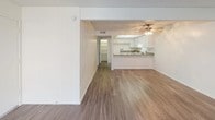 This single-floor residence offers a clean, functional layout designed for comfortable everyday living. The open-concept living and dining area is finished with smooth wood-style flooring and features a large window dressed with vertical blinds, allowing abundant natural light to fill the space. A ceiling fan overhead adds both style and practicality to this central gathering area.

The kitchen flows seamlessly from the living area via a convenient pass-through counter. It is well-appointed with ample white cabinetry, granite-style countertops, a full suite of white appliances including an electric range, and a stainless steel sink — all set on durable wood-style flooring. A hallway connects the kitchen area to the rest of the home.

The bedroom is a generously sized, quiet retreat featuring plush wall-to-wall carpeting and a large window with vertical blinds that invite natural light. The textured ceiling adds a subtle design detail consistent throughout the home.

The bathroom is neatly designed with a white vanity cabinet topped with a granite-style countertop and a wide mirror, offering ample storage and counter space. A separate water closet houses a shower-tub combination with wood-style flooring, completing the functional layout of this well-maintained residence.