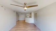 Located at 9804 Bernwood Place Dr in Fort Myers, FL, this single-floor, 3-bedroom, 2-bathroom residence offers a bright and functional layout designed for comfortable living. The open-concept living and dining area is finished with light wood-tone flooring and features a stylish gold ceiling fan with integrated lighting, creating an airy and welcoming atmosphere. The kitchen is outfitted with white cabinetry, granite-look countertops, a peninsula breakfast bar, and white appliances including a refrigerator and electric range — all tied together with clean, modern finishes. Three bedrooms provide comfortable retreats, each carpeted and filled with natural light through windows overlooking the surrounding greenery. The spacious primary bedroom offers generous proportions. Two full bathrooms are finished in neutral tones, with one featuring wood-look tile flooring, a white-tiled shower, and a vanity with a stone-look countertop. Two closets with wire shelving systems provide practical storage throughout the home. A connecting hallway links the private areas of the residence. The overall palette of whites and light neutrals lends the space a clean, move-in-ready appeal suited to a variety of living styles.
