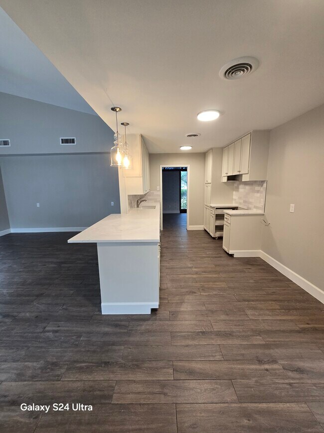 Vista de la cocina desde el área de lavandería y medio baño. - 1503 17th Ave N