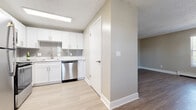 This single-floor unit offers a thoughtfully updated interior finished in a neutral, warm palette throughout. The kitchen serves as a functional centerpiece, featuring white shaker-style cabinetry, marble-look countertops, and a grey subway tile backsplash. Stainless steel appliances—including a refrigerator, range, and dishwasher—complement the space, while light luxury vinyl plank flooring adds a clean, modern feel.

The living area is generously sized, with multiple windows fitted with blinds that allow abundant natural light to filter in. Baseboard heating runs along the perimeter, and the textured ceiling is consistent throughout the unit. The flooring transitions to medium-toned vinyl plank in secondary living spaces, providing a cohesive look.

The bedrooms feature soft, neutral carpet and ceiling fans with lighting. Each bedroom includes a sliding-door closet offering practical storage. The bathroom is well-appointed with a white vanity, marble-look countertop, tile surround tub-shower combination, and matching vinyl plank flooring. Overall, the unit presents a clean, move-in-ready environment with consistent, updated finishes.