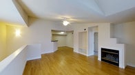 This 2-bedroom, 1-bathroom single-floor residence at Green Ash offers a well-designed layout with a bright, open-concept living area at its heart. The spacious living room features warm hardwood flooring that extends throughout, a ceiling fan for year-round comfort, and a classic fireplace that serves as a focal point along one wall. Built-in shelving niches provide convenient storage and display space, adding architectural character to the room. A pass-through breakfast bar connects the living area to the kitchen, creating an open and interactive flow ideal for everyday living and entertaining. The kitchen is defined by a dark-topped counter bar that contrasts neatly with the light walls and flooring. The neutral, light-toned walls throughout lend the space a clean and airy ambiance, allowing natural light to reflect and brighten each room. The layout is thoughtfully arranged on a single level, making the home easily navigable and accessible. Subtle architectural details, including recessed areas and defined transitions between spaces, add depth and dimension to the overall design. The combination of functional built-ins, a cozy fireplace, and cohesive flooring makes this residence a comfortable and practical living environment.