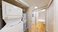 Located at 219 E Garfield St in Seattle's Capitol Hill neighborhood, this single-floor unit offers a clean, modern layout designed for efficient use of space. The interior is finished with warm-toned hardwood-style flooring that runs continuously throughout, lending a cohesive and inviting feel to the entire unit.

The living area is open and well-proportioned, featuring neutral white walls, recessed lighting, and clean white baseboards that contribute to a bright, minimalist aesthetic. A large window allows natural light to filter in, with views of lush greenery outside. The space connects seamlessly to a compact kitchen area outfitted with light maple cabinetry, a full-size refrigerator, and black appliances, providing functional storage and prep space.

A hallway connects the main living area to the private spaces, including a full bathroom. The bathroom is finished with the same wood-tone flooring and features a full-size tub and shower combination with brushed nickel fixtures, a toilet, and a vanity with a dark granite countertop and an undermount sink. A large mirror above the vanity enhances the sense of space.

Throughout the unit, the design is clean and contemporary, with recessed lighting providing consistent illumination. The overall ambiance is calm and practical, making this a well-appointed space in a desirable Seattle location.