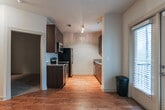 Located in the vibrant Old Fourth Ward neighborhood of Atlanta, GA, this single-floor residence offers a well-designed layout with a cohesive blend of modern finishes and functional living spaces. Rich hardwood flooring flows throughout the main living areas, lending warmth and continuity to the home.

The galley-style kitchen is a standout feature, outfitted with dark espresso cabinetry, granite countertops, and a full suite of stainless steel appliances including a refrigerator, dishwasher, microwave, and range. Track lighting overhead adds a contemporary touch, while a window above the sink allows for natural light to brighten the workspace.

The living area is open and airy, featuring a ceiling fan with light fixture and a built-in nook that adds an architectural detail to the room. French doors at the end of the hallway invite natural light deep into the unit, enhancing the overall brightness of the space.

The bathroom is finished with large-format tile flooring, a granite-topped dark wood vanity, a well-lit mirror, and a tiled shower-tub combination, creating a clean and polished aesthetic. A dedicated in-unit laundry closet houses a stacked washer and dryer, adding everyday convenience. The hallway connects all areas efficiently, making the layout practical and easy to navigate.