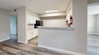 Located in Houston's 77083 zip code, this single-story, 3-bedroom, 2-bathroom home offers a well-organized layout with consistent modern finishes throughout. Durable wood-look vinyl plank flooring runs through all rooms, complemented by neutral warm-gray walls and clean white baseboards, creating a cohesive and contemporary aesthetic.

The living room is a comfortable, open space featuring a ceiling fan with light fixture and a sliding glass door that leads to the patio, allowing natural light to fill the room. Adjacent to the living area, the kitchen is equipped with crisp white shaker cabinets, granite-style countertops, black appliances including an electric range, and a pass-through breakfast bar that connects to the main living space.

The primary bedroom offers a generous footprint with a dedicated closet featuring a full-width hanging rod. Additional bedrooms include windows with blinds for natural light and privacy. The two bathrooms are finished with matching vinyl plank flooring and granite vanity tops; one features an accessible design with grab bars and an open vanity, while the other includes a standard tub-shower combination with white tile surround.

A dedicated laundry area houses the water heater and washer/dryer hookups, adding practical functionality. The home also includes a patio for outdoor enjoyment.