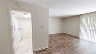Located at 1615 Williams St in Valdosta, Georgia, this single-floor unit offers a clean, functional layout with consistent wood-look flooring throughout the main living and bedroom areas. The living room is generously sized, featuring neutral walls, white trim, and a large vertical-blind window that allows an abundance of natural light to fill the space, creating a bright and open atmosphere.

The kitchen is appointed with white cabinetry, granite-look countertops, light tile flooring, and includes a built-in microwave above the electric range — offering a practical and well-equipped cooking space. An adjacent area provides a seamless transition between the kitchen and living zones.

The bedrooms are well-proportioned, each featuring the same wood-look flooring and neutral tones. One bedroom includes a spacious reach-in closet and a tall window that brings in natural light. Additional rooms offer flexible storage options with built-in closet access.

The bathroom is neatly finished with a granite-top vanity, white cabinetry, a large mirror, mosaic tile flooring, and a shower-tub combination, maintaining a cohesive and clean aesthetic throughout. Hallways connect the rooms efficiently, with louvered closet doors adding a classic touch. Overall, the unit presents a tidy, move-in-ready environment with consistent finishes throughout.