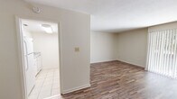 Located at 1615 Williams St in Valdosta, Georgia, this single-floor unit offers a clean, functional layout with consistent wood-look flooring throughout the main living and bedroom areas. The living room is generously sized, featuring neutral walls, white trim, and a large vertical-blind window that allows an abundance of natural light to fill the space, creating a bright and open atmosphere.

The kitchen is appointed with white cabinetry, granite-look countertops, light tile flooring, and includes a built-in microwave above the electric range — offering a practical and well-equipped cooking space. An adjacent area provides a seamless transition between the kitchen and living zones.

The bedrooms are well-proportioned, each featuring the same wood-look flooring and neutral tones. One bedroom includes a spacious reach-in closet and a tall window that brings in natural light. Additional rooms offer flexible storage options with built-in closet access.

The bathroom is neatly finished with a granite-top vanity, white cabinetry, a large mirror, mosaic tile flooring, and a shower-tub combination, maintaining a cohesive and clean aesthetic throughout. Hallways connect the rooms efficiently, with louvered closet doors adding a classic touch. Overall, the unit presents a tidy, move-in-ready environment with consistent finishes throughout.