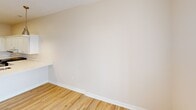 Located at 900 Third St SE in Cedar Rapids, Iowa, this one-bedroom, one-bathroom unit offers a functional and modern single-floor layout. Warm-toned luxury vinyl plank flooring runs throughout the main living areas, complemented by neutral walls that create a clean, bright atmosphere.

The kitchen and dining area form a combined open space anchored by crisp white shaker cabinetry extending to the upper walls, providing ample storage. Stainless steel appliances—including a French door refrigerator, range, and built-in microwave—add a contemporary touch, while recessed and pendant lighting illuminate the workspace. The countertops are finished in a light, solid surface material with an integrated sink.

The bathroom is thoughtfully designed with accessibility in mind, featuring a roll-in shower equipped with grab bars, a handheld showerhead, and a fold-down bench. Light wood-look flooring, a wall-mounted vanity, and an adjacent in-unit washer and dryer add practicality.

The bedroom offers plush carpeting, a ceiling fan, a window with natural light and exterior views, and two generously sized closets with built-in shelving—providing substantial storage for everyday living.