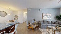 This thoughtfully designed single-floor residence offers a comfortable and cohesive living experience with a modern yet warm aesthetic throughout. The open-concept layout connects the living room, kitchen, and dining area seamlessly, creating a welcoming flow ideal for everyday living.

The living room is highlighted by a soft blue accent wall, wood-look flooring, a ceiling fan, and a bright window that allows natural light to fill the space. The kitchen is well-equipped with rich warm-toned cabinetry, granite countertops, stainless steel appliances including a refrigerator and range, and a dishwasher. Adjacent to the kitchen is a cozy dining nook with light wood flooring, pendant lighting, and open corner shelving.

The two bedrooms are carpeted for comfort and each features a ceiling fan, natural light from windows with blinds, and ample space for furnishings. The full bathroom includes a shower-tub combination, toilet, and wood-look flooring, with convenient storage space just outside.

A hallway with a closet connects the private areas of the home, maintaining a clear separation between living and sleeping spaces. The overall palette of neutral whites, soft blues, and warm wood tones creates a calm and inviting atmosphere throughout.