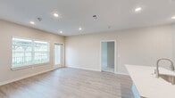 Located at 5045 Burke Road in Pasadena, TX, this single-story 2-bedroom, 2-bathroom home offers a clean, modern design with a well-planned open-concept layout. The welcoming entrance flows into a bright living area featuring light wood-style flooring, recessed lighting, and neutral toned walls that create an airy, cohesive atmosphere throughout. Natural light enters through multiple windows, enhancing the sense of openness.

The kitchen is a standout feature, showcasing a central island with a built-in sink and white quartz countertops, rich dark walnut cabinetry on the lower level, crisp white upper cabinets, and stainless steel appliances including a refrigerator, range, and microwave. A pantry provides additional storage to keep the kitchen organized.

Both bedrooms are carpeted for comfort and include ceiling fans and windows that bring in natural light. The spacious primary bedroom connects to a well-appointed bathroom with a modern vanity and ample cabinet storage. A dedicated walk-in closet with built-in shelving and hanging rods adds practical functionality. Three closets in total ensure generous storage throughout the home.

The two bathrooms feature light wood flooring and contemporary vanity cabinetry. A dedicated laundry room rounds out the home's practical offerings, making this a complete and well-equipped residence.