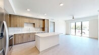 Located at 425 Centerpointe Circle in Altamonte Springs, FL, this thoughtfully designed 2-bedroom, 2-bathroom residence offers a modern aesthetic across a single floor. The open-concept living area seamlessly connects the kitchen, dining, and living spaces, creating an airy and functional environment bathed in natural light from large sliding glass doors that lead to the outdoors.

The kitchen is a standout feature, showcasing light wood cabinetry that extends to the ceiling, a textured tile backsplash, quartz countertops, and a full suite of stainless steel appliances. A central island provides additional prep space and casual seating. Light-toned wood-style flooring flows throughout the main living areas, complementing the clean, neutral palette.

The primary bedroom is generously sized, featuring a ceiling fan, large windows with outdoor views, and direct access to a private en-suite bathroom. The bathrooms are finished with elegant marble-look tile flooring, wood-toned vanities with white quartz countertops, and glass-enclosed fixtures. One bathroom features a walk-in shower, while the other includes a soaking tub and shower combination.

Additional highlights include dedicated closet spaces, an in-unit laundry area, and a utility room, making this a complete and well-organized residence in a contemporary setting.