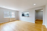 Located on John F. Kennedy Blvd E in North Bergen, NJ, this well-appointed 2-bedroom, 1-bathroom residence offers a thoughtfully designed single-floor layout with consistent warmth and character throughout. Gleaming hardwood floors extend across every room, complemented by clean white trim and neutral gray walls that create a bright, cohesive aesthetic.

The open-concept living and dining area is generously proportioned, featuring recessed lighting and a pass-through window that connects seamlessly to the kitchen — complete with white cabinetry, stainless steel appliances, a mosaic tile backsplash, and a breakfast bar. The kitchen also enjoys its own window, filling the space with natural light and outdoor views.

Both bedrooms are comfortable and well-lit, each with hardwood flooring, windows with green outdoor views, and classic cast-iron radiators. The spacious primary bedroom offers ample room and closet access. A total of five closets throughout the unit provides excellent storage capacity.

The hallway and entrance flow efficiently through the layout, connecting all areas with ease. The full bathroom features a white-tiled tub-surround, a modern wood-tone vanity with an integrated sink, and a window for natural ventilation. Classic radiator heating is present throughout, underscoring the unit's blend of timeless character and modern updates.